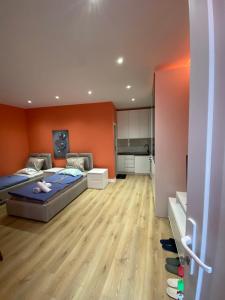 a bedroom with two beds and an orange wall at Tirana Center Apartaments in Tirana