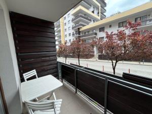 a balcony with a bench and a table and a building at RBC Apartments with garden view in Cluj-Napoca