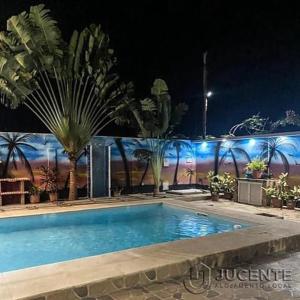 a swimming pool at night with palm trees at JUCENTE_ALOJAMENTO_LOCAL in Quifica