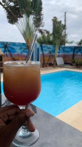 a person holding a drink in front of a pool at JUCENTE_ALOJAMENTO_LOCAL in Quifica