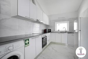 a white kitchen with a washing machine and a sink at Charming Villa Sam in Albufeira
