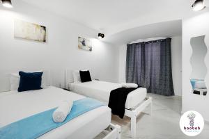 two beds in a white room with a window at Charming Villa Sam in Albufeira