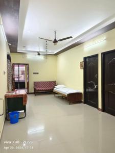 a room with two beds and a couch in it at Sai Home Stay in Tiruvannāmalai