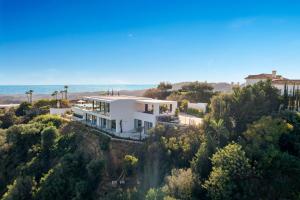 een huis op een heuvel met de oceaan op de achtergrond bij Exclusive VILLA IMAGINE MARBELLA breathtaking panoramic sea views heated infinity pool in Benahavís