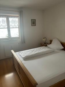 a large white bed in a room with a window at Sonnenblick in Bad Tölz