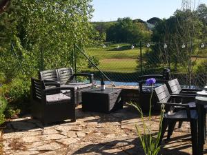 a patio with chairs and tables with a view of a field at La planque de l'éclusier in Castelnau-de-Lévis