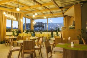 un restaurante con mesas, sillas y ventanas en Lotus Inn, en Atenas