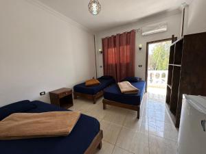 a hotel room with two beds and a window at Seven Heaven Hotel And Diving Center in Dahab