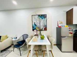uma sala de estar com uma mesa branca e um frigorífico em Livahome - BEE Lux homestay Di An em Dĩ An