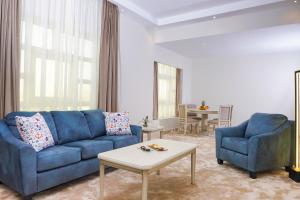 a living room with a blue couch and two chairs at Triumph Plaza Hotel in Cairo