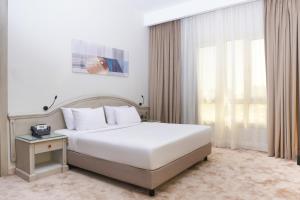 Un dormitorio con una gran cama blanca y una ventana en Triumph Plaza Hotel, en El Cairo