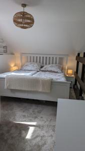 - une chambre avec un lit blanc et un lustre dans l'établissement Ferienhaus nahe Krautsand, à Drochtersen