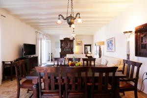 a dining room and living room with a table and chairs at On the Rocks Villa at Cavo Delos in Agios Ioannis Mykonos
