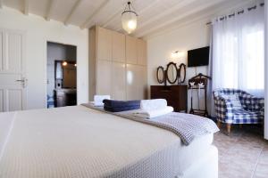 a bedroom with a large white bed in a room at On the Rocks Villa at Cavo Delos in Agios Ioannis Mykonos