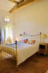 1 dormitorio con 1 cama con sábanas y almohadas blancas en As seen on A New Life in The Sun - Beautiful 3 bedroom cottage with shared pool, en Montboyer