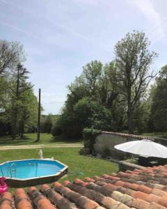 una piscina con sombrilla junto a un patio en As seen on A New Life in The Sun - Beautiful 3 bedroom cottage with shared pool, en Montboyer