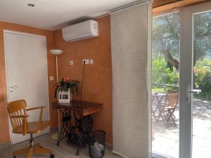 a room with a sliding glass door with a table and a chair at Moulin - Studio charmant avec terrasse - 3 étoiles in Dieulefit