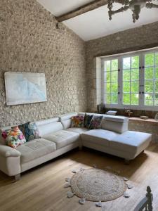 una sala de estar con un sofá blanco en una habitación en As seen on A New Life in The Sun - Beautiful 3 bedroom cottage with shared pool, en Montboyer