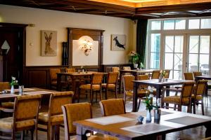 a restaurant with tables and chairs in a room at Landhaus Lellichow in Lellichow