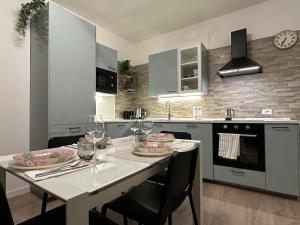 uma cozinha com uma mesa branca com cadeiras e copos em [Venezia-Mestre] Design Apartment Bros#1 em Veneza