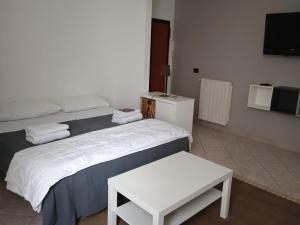 Schlafzimmer mit einem Bett, einem Tisch und einem TV in der Unterkunft Casa Di Francesco in Velletri