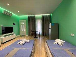 two beds in a room with green walls at Tirana Center Apartaments in Tirana