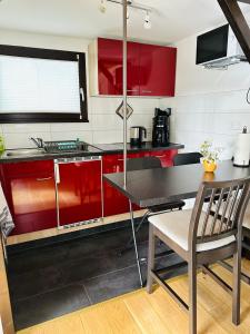 a kitchen with red cabinets and a table with chairs at Haus Andrea in Himmelpfort