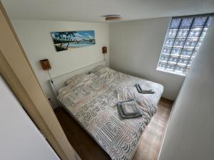 Habitación pequeña con cama y ventana en Bed & Beach Noordwijk - 200m from beach and free parking en Noordwijk aan Zee