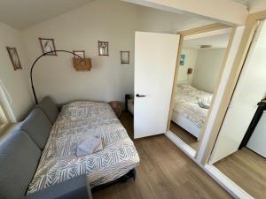 Habitación pequeña con cama y puerta a un dormitorio en Bed & Beach Noordwijk - 200m from beach and free parking, en Noordwijk aan Zee