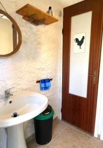 un bagno con lavandino, specchio e porta di Lavender Glamping a Elmas