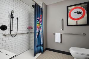 a bathroom with a shower curtain and a toilet at Moxy Chicago Downtown in Chicago