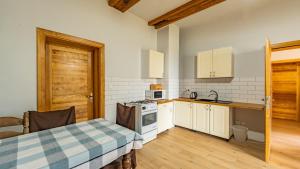 eine Küche mit weißen Schränken und einer Holztür in der Unterkunft Dom Przy Puszczy Noteckiej 