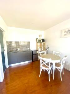 a kitchen and dining room with a table and chairs at Self contained guest house - sleeps 4 in Gold Coast