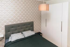 ein Schlafzimmer mit einem grünen Bett und einer Wand in der Unterkunft Gonsiori Apartment in Tallinn