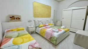 - une chambre avec 2 lits et un tableau mural dans l'établissement Casa Vacanza Trono Del Sol, à Vietri
