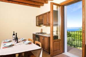 eine Küche mit einem Tisch und Meerblick in der Unterkunft Roel Apartments Lazise in Calmasino