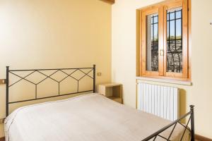 Schlafzimmer mit einem Bett und einem Fenster in der Unterkunft Roel Apartments Lazise in Calmasino