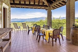eine Terrasse mit Tischen und Stühlen und Meerblick in der Unterkunft Roel Apartments Lazise in Calmasino