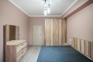 um quarto com armários de madeira e um tapete azul em New Kond appartment em Yerevan