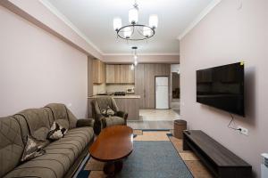 uma sala de estar com um sofá e uma televisão de ecrã plano em New Kond appartment em Yerevan