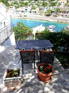 d'une table, de chaises et de quelques fleurs. dans l'établissement Apartment Teuta, à Žirje