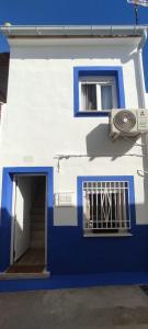 un edificio blu e bianco con una porta e una finestra di La Casita El Carmen a Quintanar de la Orden