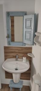 een badkamer met een witte wastafel en een spiegel bij La Casita El Carmen in Quintanar de la Orden