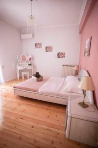 sypialnia z dużym łóżkiem i drewnianą podłogą w obiekcie Casa di Michele w mieście Perama