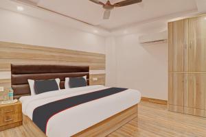 a bedroom with a large bed and a ceiling fan at Hotel Ganga Sports in Haridwār
