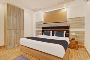 a bedroom with a large bed with a wooden headboard at Hotel Ganga Sports in Haridwār