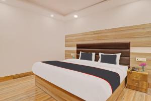 a bedroom with a large bed with a wooden headboard at Hotel Ganga Sports in Haridwār