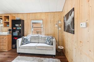 a couch in a living room with wooden walls at Cabin 10- Cozy Toronto Lake Cabin - Walk to the Water cabin in Toronto