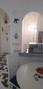 a kitchen with a white table and a table and chairs at Bel appartement au coeur du Port El Kantaoui in Port El Kantaoui