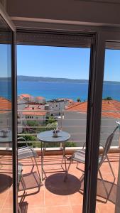 un patio con tavolo e sedie sul balcone. di Luxury Apartments Villa Lenka a Podstrana